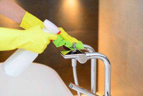 Cleaner wiping communal touchpoints in a Pimlico block